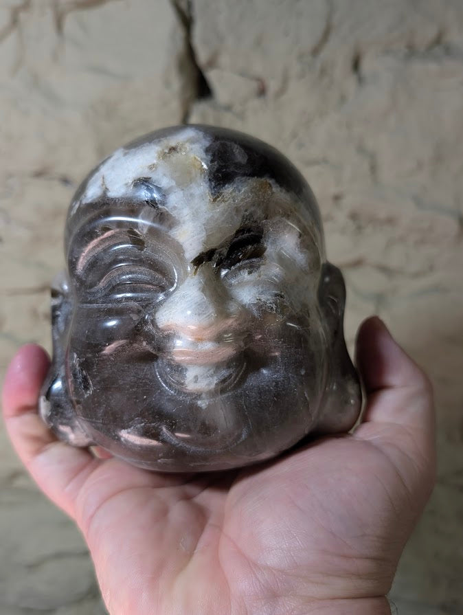 Silver Mica Laughing Buddha head in hand for scale—1.97 kg