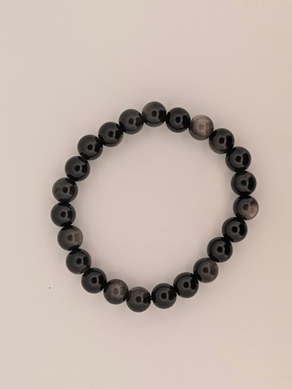 Top-down view of 8mm silver sheen obsidian bracelet on white background