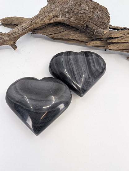 Pair of Silver Sheen Obsidian hearts showing black glass and silver banding.