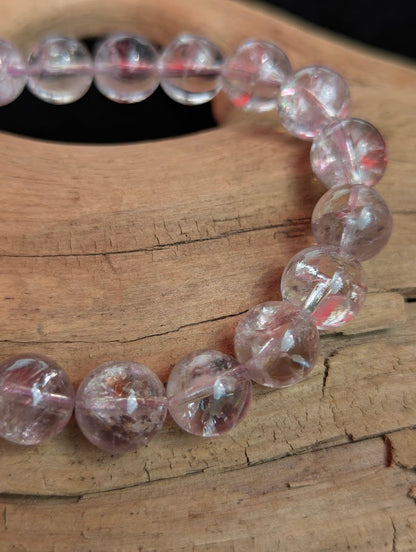 Macro close-up of 10mm Smoky Amethyst beads highlighting the iridescent iris quartz optical effect and smooth spherical polish.