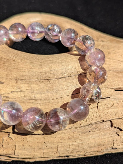 Macro shot of 11mm Smoky Amethyst beads displaying subtle amethyst violet and smoky quartz colour zoning.