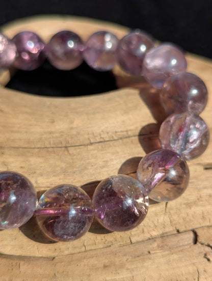 Macro close-up of 13mm Smoky Amethyst beads displaying high translucency and internal rainbow fractures.