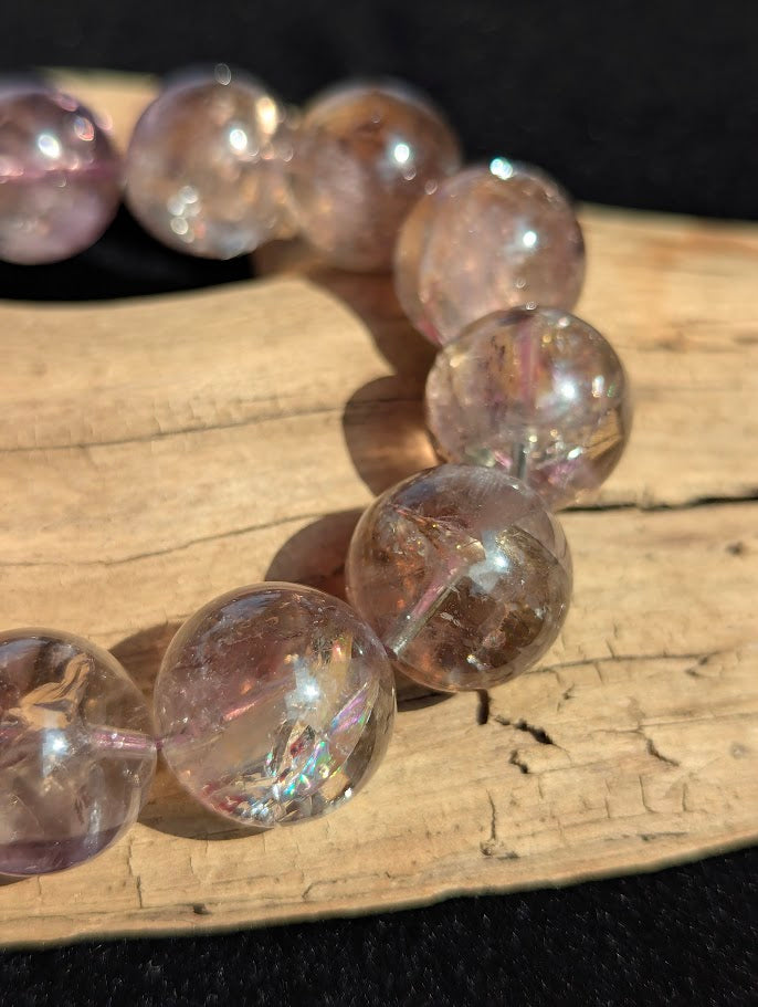 Intuitively selected 18mm statement AA Grade Smoky Amethyst beaded stretch bracelet resting on driftwood, showcasing large collector spheres.