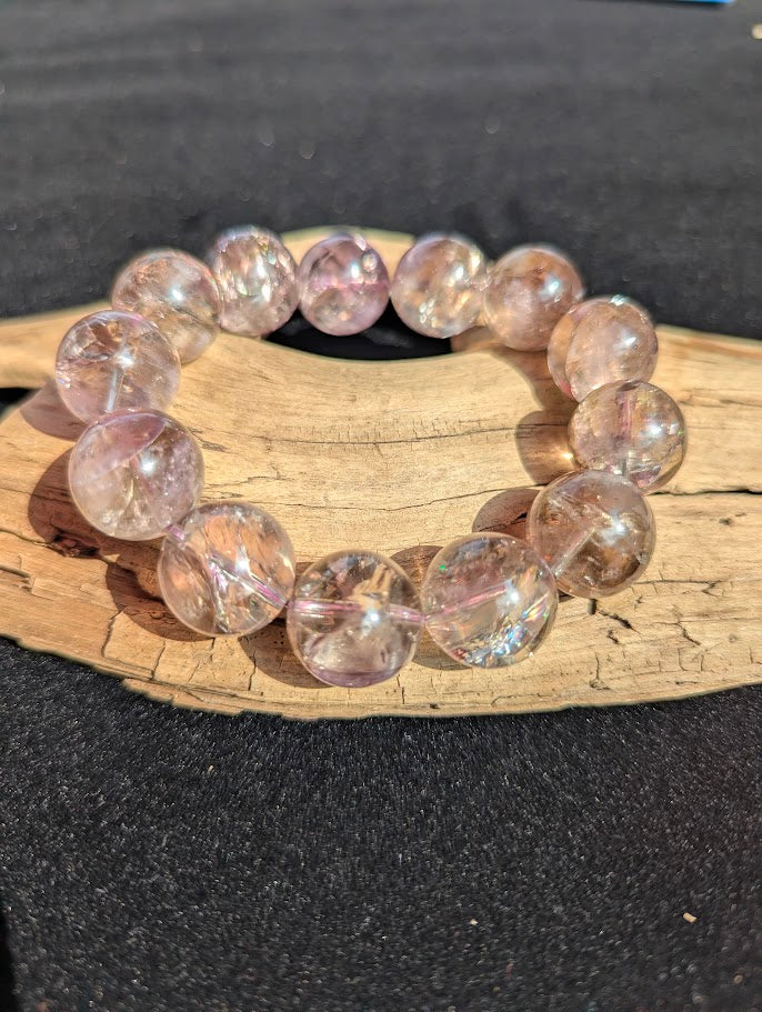 Macro view of 18mm large Smoky Amethyst spheres highlighting optical clarity, smoky-lilac hues, and internal rainbow flashes.