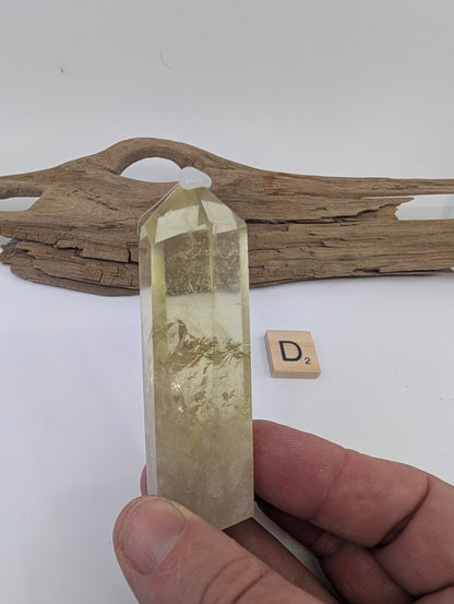 Hand holding Piece D, an 83mm polished Smoky Citrine tower from Brazil with an internal rainbow.