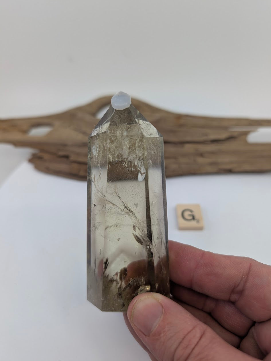 Hand holding Piece G, a chunky 90mm polished Smoky Citrine tower from Brazil with deep grounding tones.