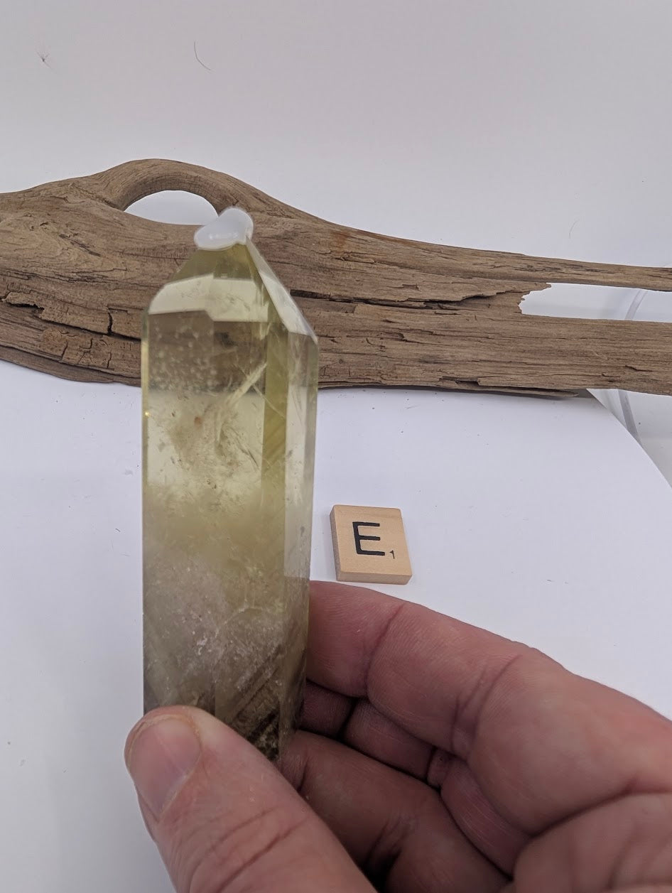Hand holding Piece E, a tall 92mm slender polished Smoky Citrine tower from Brazil.