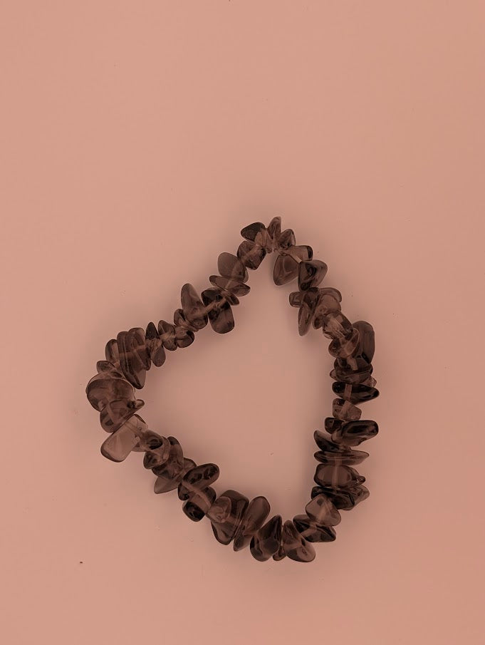 Top-down view of smoky quartz chip bracelet on white background