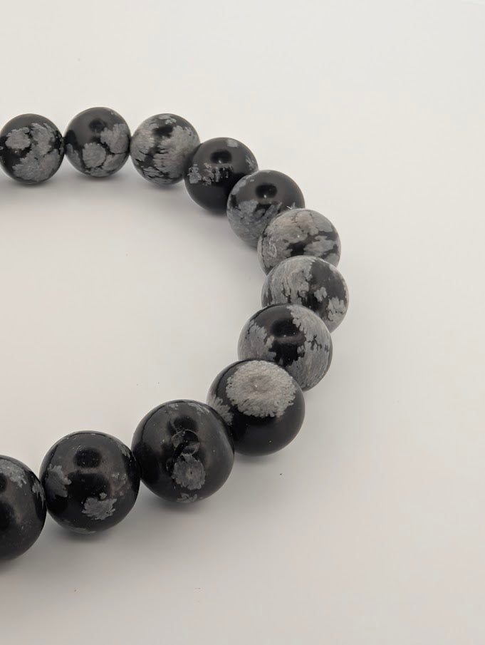 Detail of polished 8MM Snowflake Obsidian bracelet beads