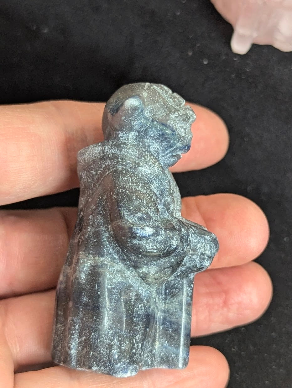 Profile view of a hand-carved Sodalite Yoda figure highlighting the detailed robe and stoic posture.