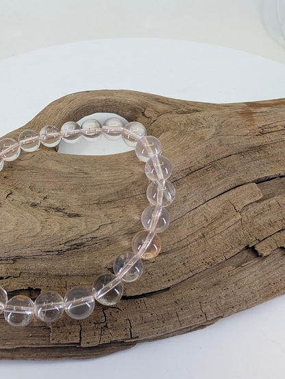 Close-up of 8mm Rose Quartz beads highlighting the internal "whisper-pink" veils and silky textures.