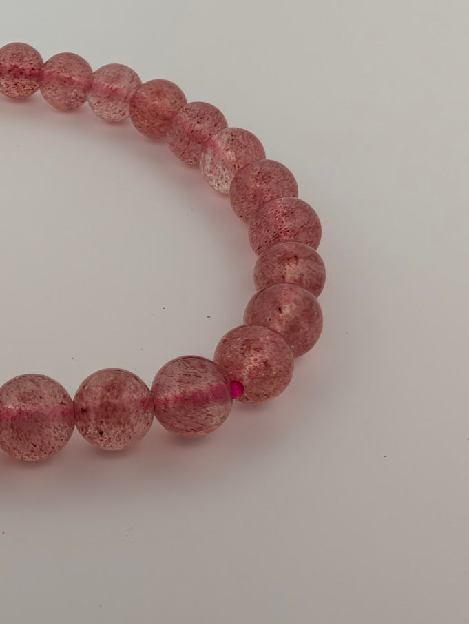 6mm Strawberry Quartz bracelet detail with polished round beads and natural inclusions