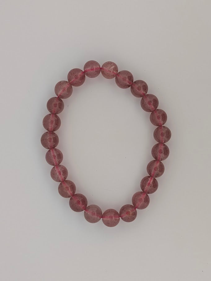 Top-down view of 8mm Strawberry Quartz bracelet on white background
