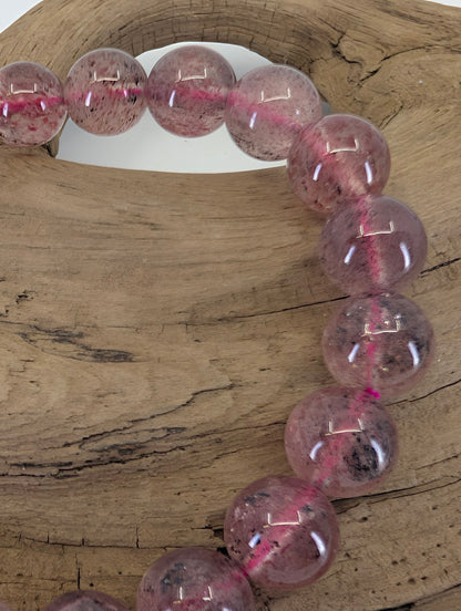 Close-up of 9mm Strawberry Quartz beads highlighting the high-clarity matrix and "seeded" mineral inclusions.