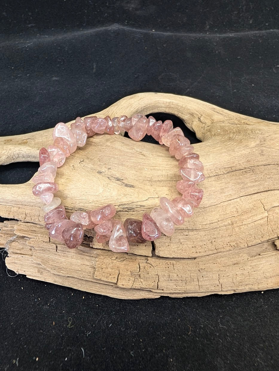 Full view of a Strawberry Quartz freeform chip bracelet on a driftwood base, showing natural pink hematite inclusions.