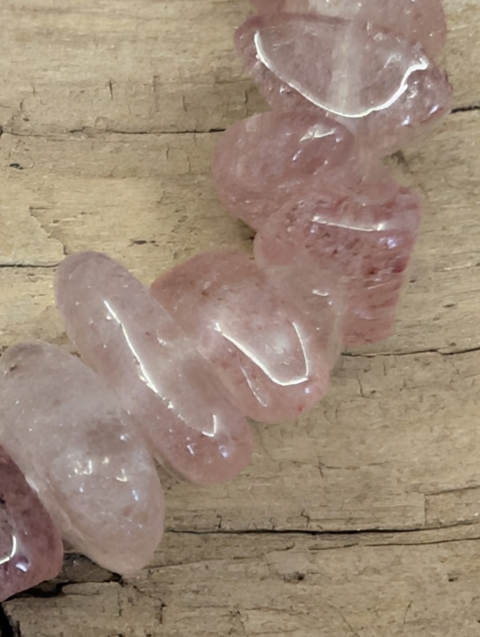 Macro shot of Strawberry Quartz freeform beads, showcasing the glassy luster and unique lepidocrocite inclusions.