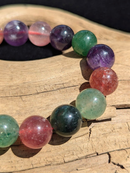 Macro close-up of 11mm polished Super 8 beads highlighting the natural inclusions and diverse mineral palette of amethyst, aventurine, and strawberry quartz.