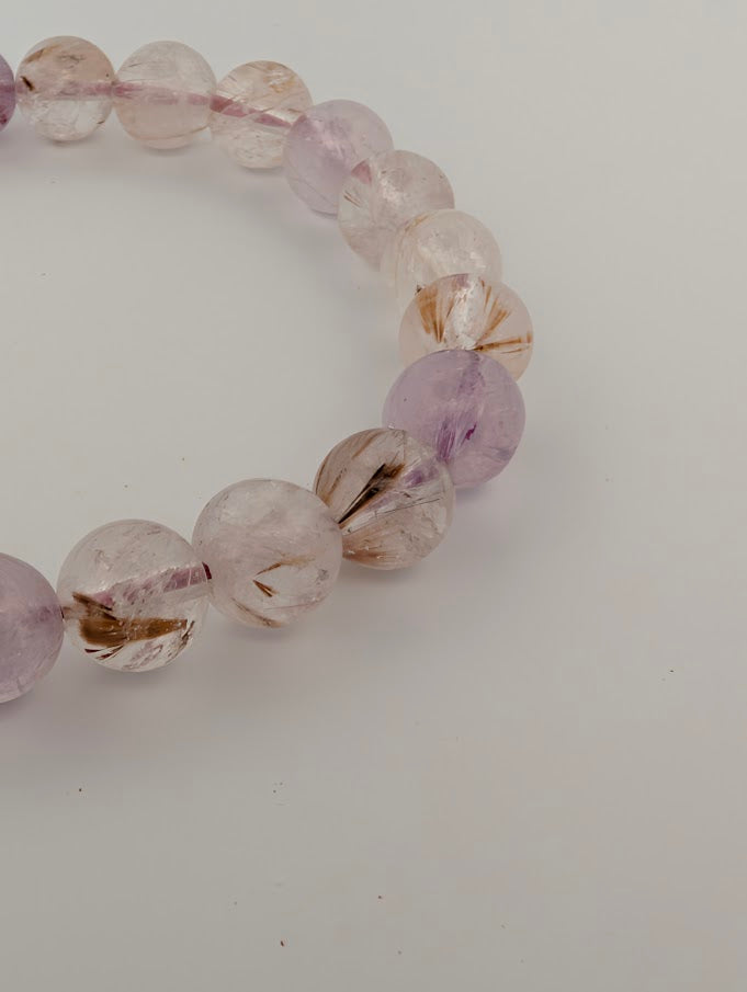 Detail of 9MM Super Seven bracelet with purple and smoky quartz tones