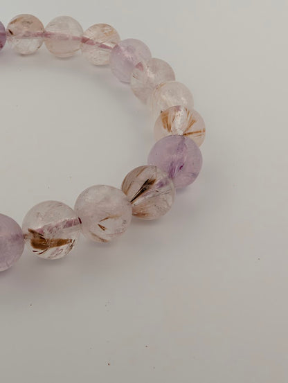 Detail of 9MM Super Seven bracelet with purple and smoky quartz tones