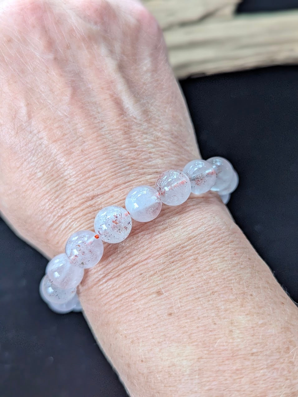 Bold 11mm Super Seven gemstone bracelet styled on a wrist, demonstrating significant size and glowing clarity.