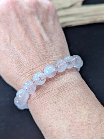 Bold 11mm Super Seven gemstone bracelet styled on a wrist, demonstrating significant size and glowing clarity.