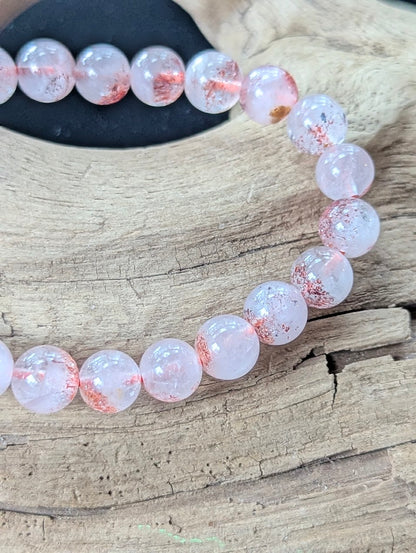 Close-up macro view of 7mm Super Seven beads displaying exceptional transparency and suspended lepidocrocite needles.