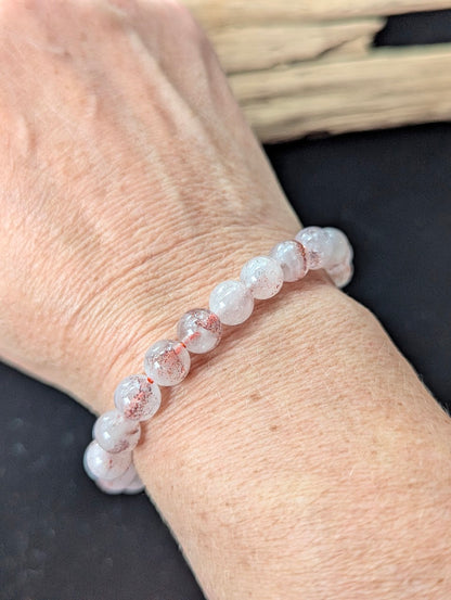8mm Super Seven gemstone bracelet styled on a wrist, demonstrating size and glowing clarity.
