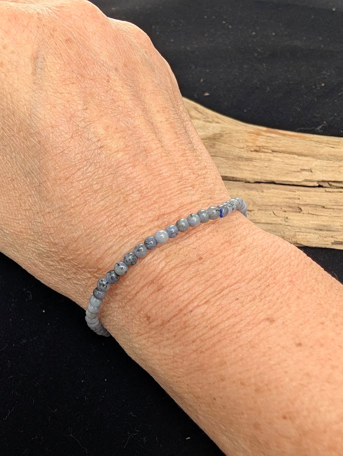 3mm polished Tanzanite beaded stretch bracelet worn on a wrist for ultra-delicate size scale.
