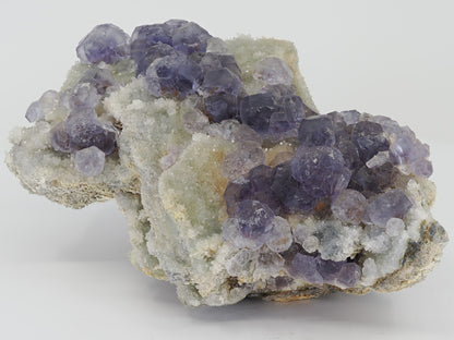 Cabinet sized Tanzanite Fluorite specimen from Fujian China featuring deep violet crystals on white drusy quartz.
