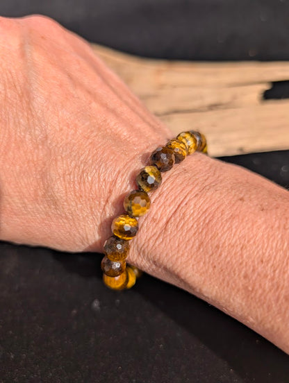8mm faceted Tiger Eye beaded stretch bracelet worn on a wrist for size scale.