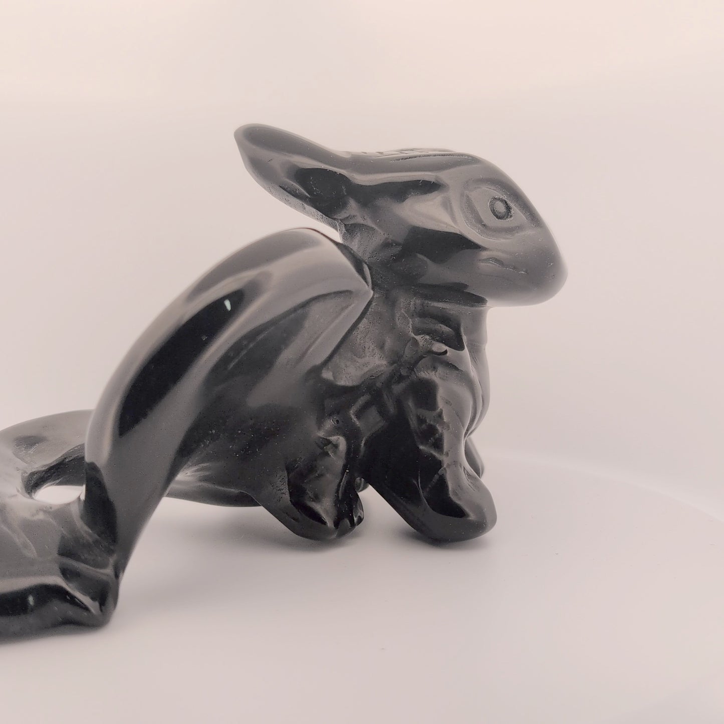 Side profile of Toothless dragon carving in obsidian, showing body shape