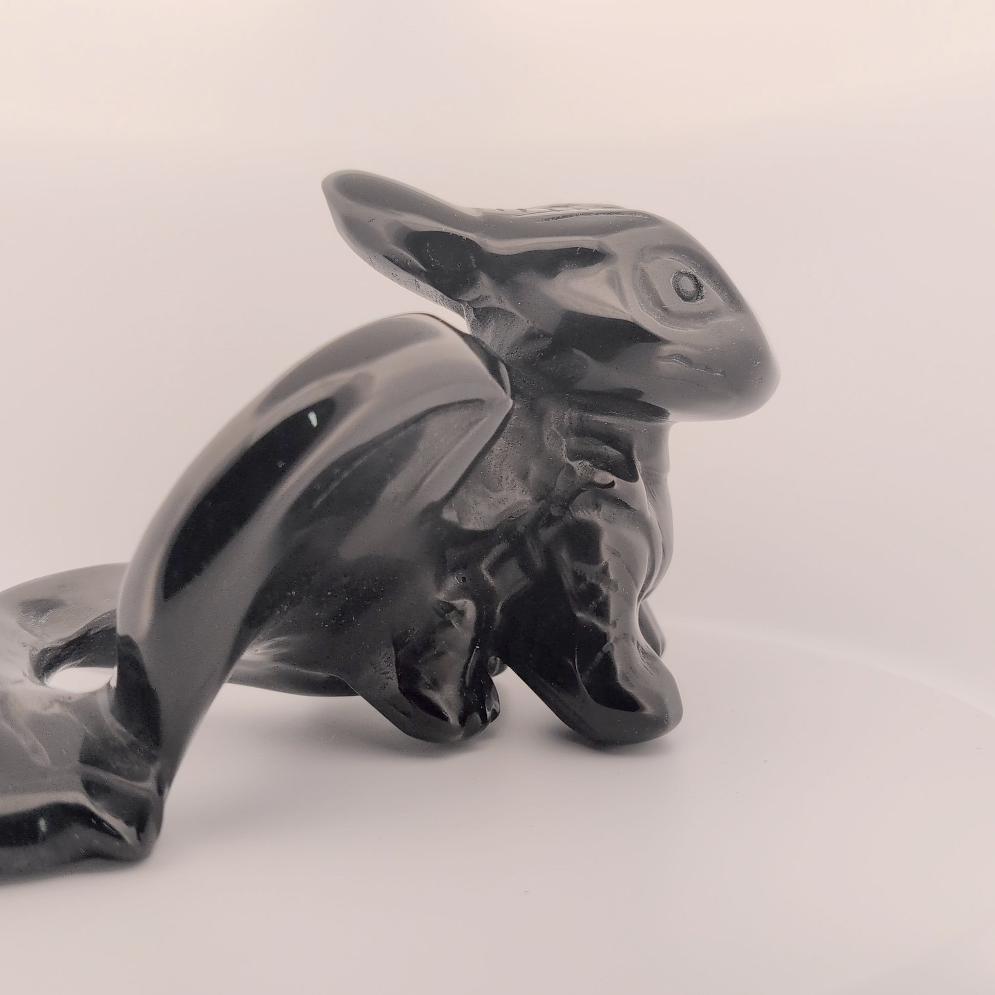 Side profile of Toothless dragon carving in obsidian, showing body shape