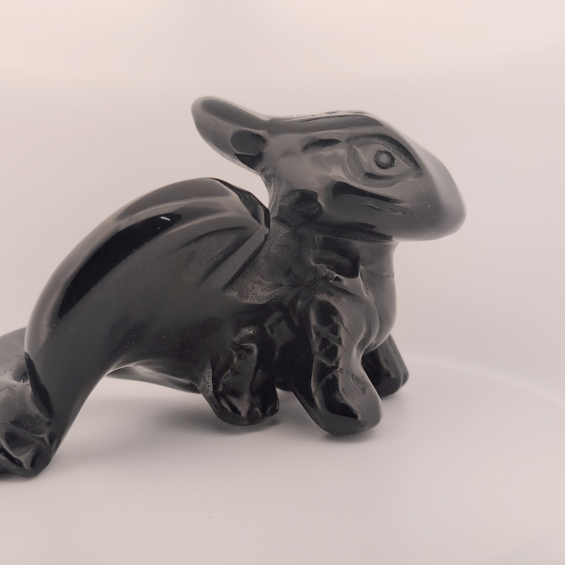 Side profile of Toothless dragon carving in obsidian, showing body shape
