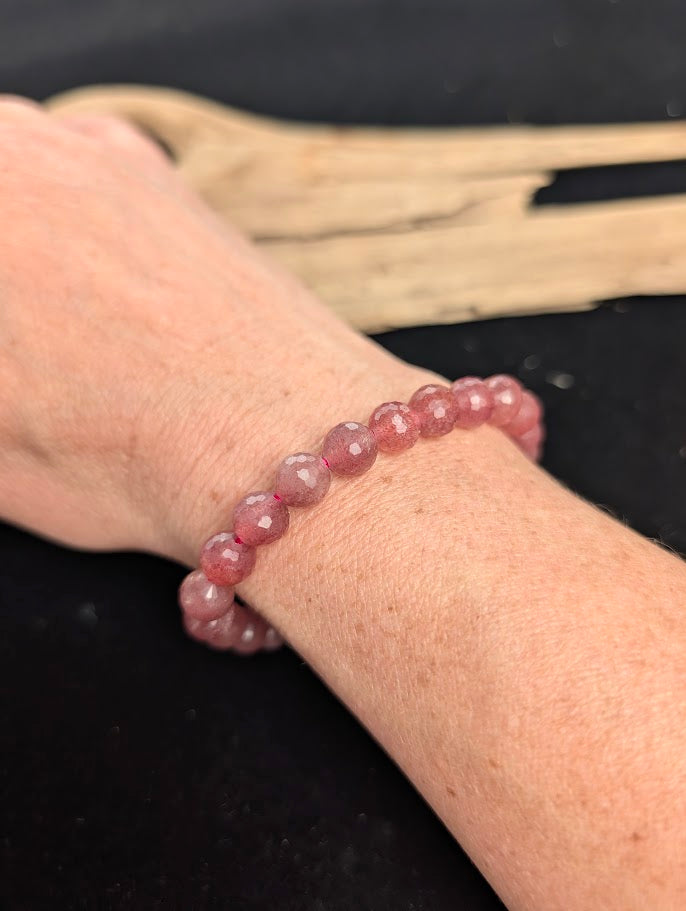 8mm faceted Strawberry Quartz beaded stretch bracelet worn on a wrist for size scale.