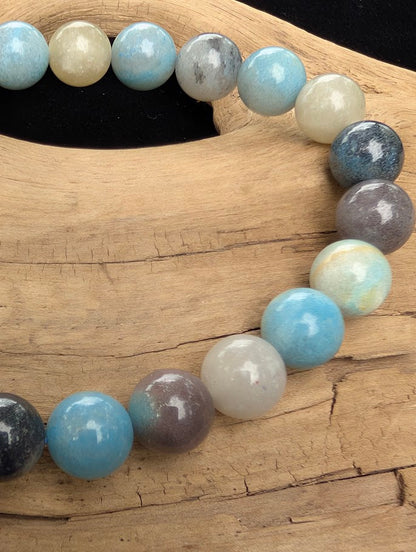 Macro close-up of 8mm polished Trolleite beads highlighting the high-gloss finish and the multi-mineral composite structure of blue and white quartz.