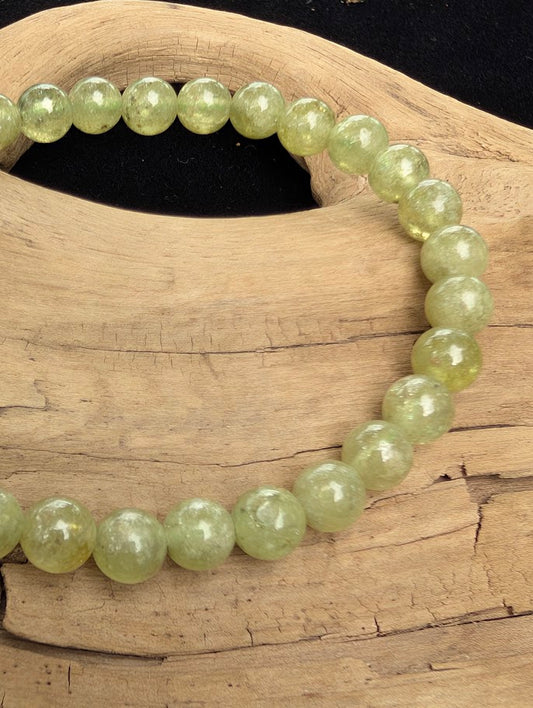Macro close-up of 7mm polished Tsavorite beads highlighting the high-gloss finish and sparkling internal fracture texture.