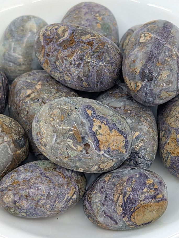 Close-up of Violet Jasper tumbled stones showing natural veining and color patterns
