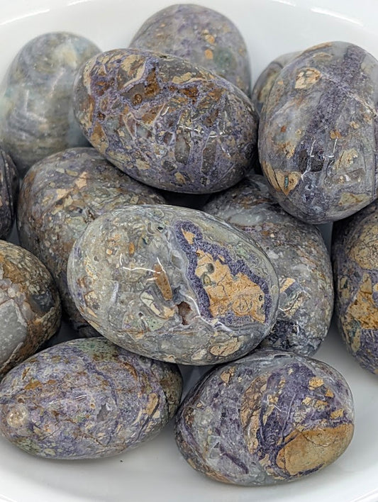 Close-up of Violet Jasper tumbled stones showing natural veining and color patterns