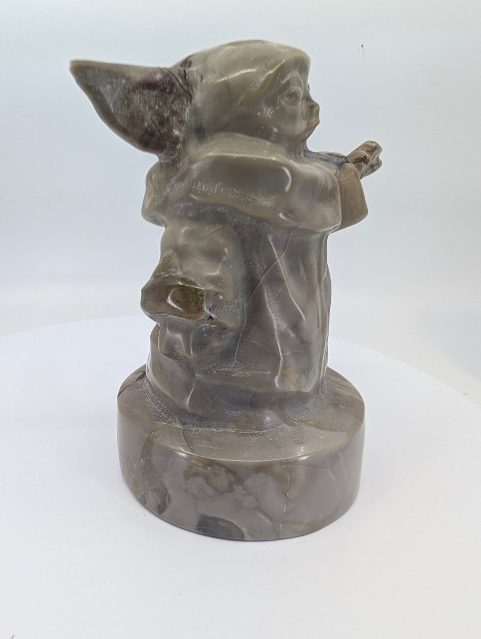 Back view of volcano agate Gorgu carving highlighting healed veins and banding