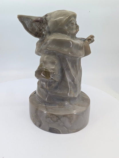 Back view of volcano agate Gorgu carving highlighting healed veins and banding