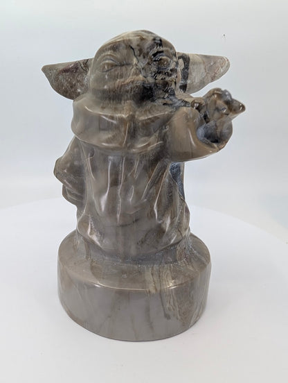 Front view of 730 g volcano agate Gorgu carving on round base