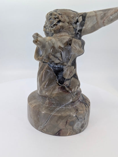 Right side view of polished volcano agate Gorgu figure on round base