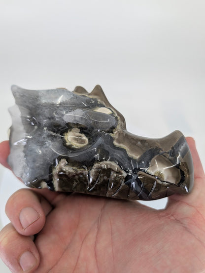 Handheld view of Volcano Agate Dragon Head Variant A highlighting size and polish