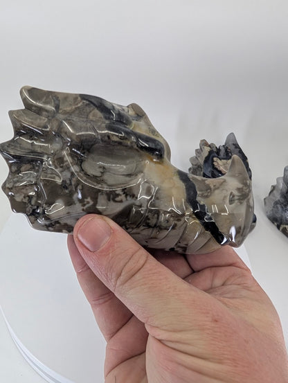 Handheld Volcano Agate Dragon Head Variant C highlighting swirling grey and black agate