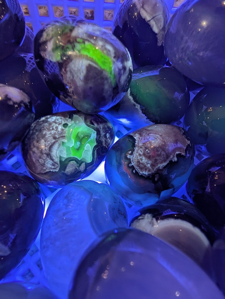 Volcano Agate eggs under 365nm UV light exhibiting intense natural neon green fluorescence.