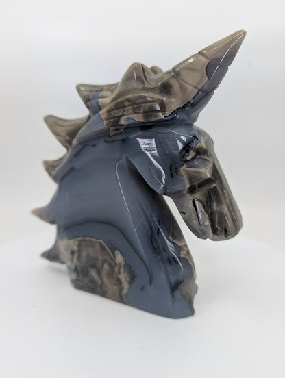 Left profile view of 620 g volcano agate unicorn head carving