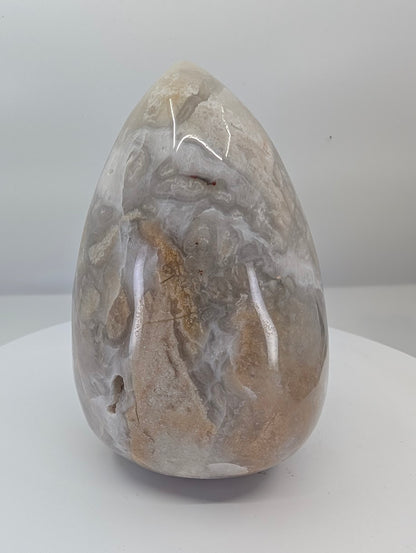 Back view of a polished white Mexican lace agate egg with layered banding