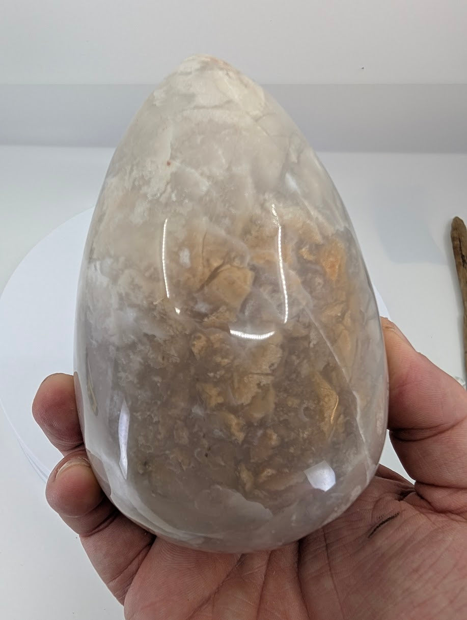 Side view of white Mexican lace agate egg showing swirling lace patterns