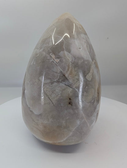 Side view of white Mexican lace agate egg showing swirling lace patterns