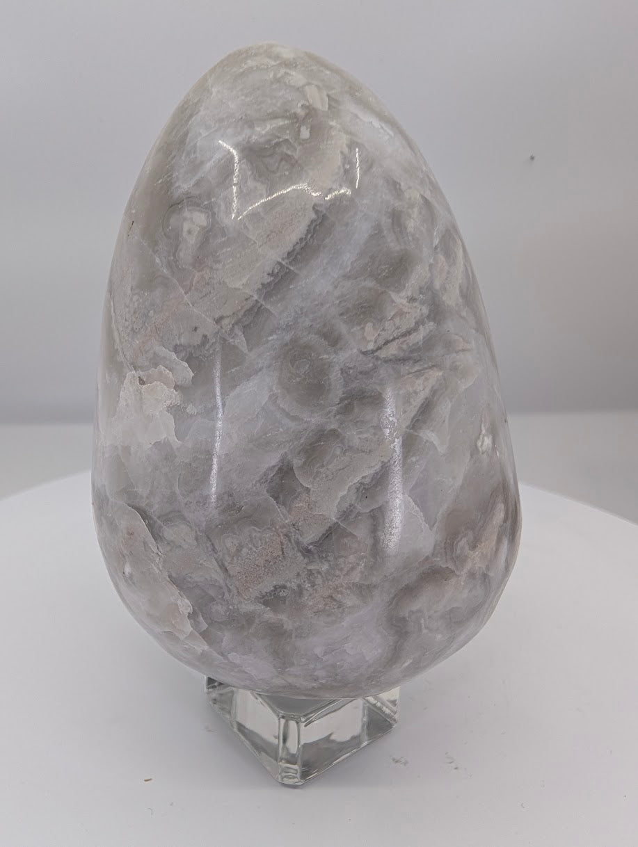 Side view of white Mexican lace agate egg showing soft grey-white banding